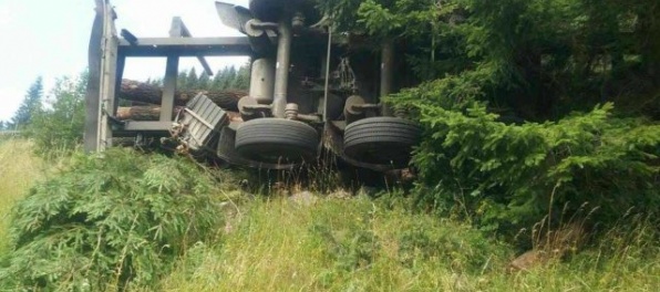 Foto: Kamión s drevom sa prevrátil do priekopy a kabína zostala zakliesnená medzi stromami