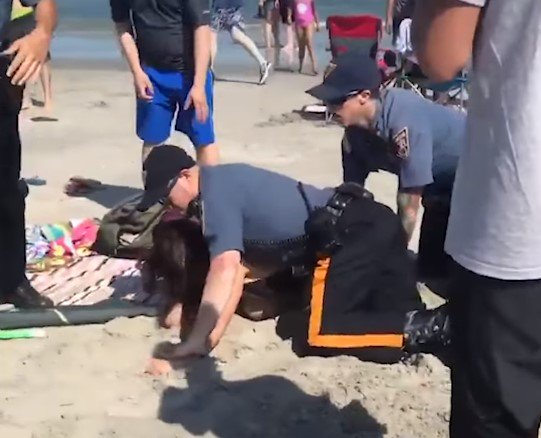 Video: Policajt udrel Emily ležiacu na pláži počas zatýkania, starosta označil prípad za hanbu