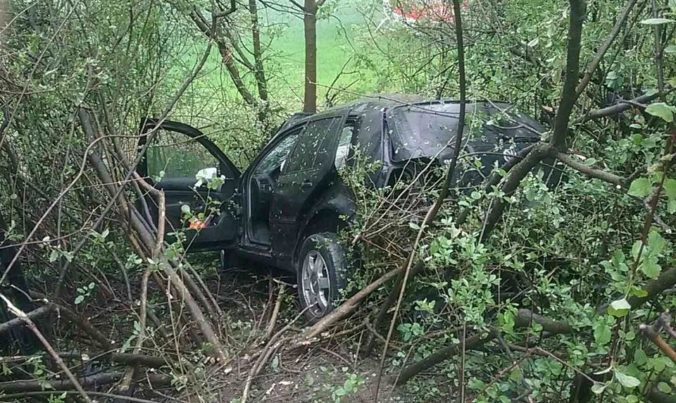 Foto: Cestu pri Prečíne museli uzavrieť, auto zostalo po nehode zakliesnené medzi stromami