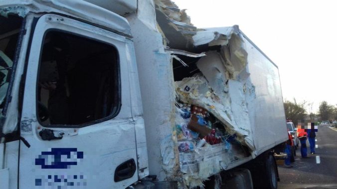 Pre nehodu dvoch kamiónov a auta museli uzavrieť cestu, vodičovi nákladiaku pomáhali von hasiči (foto)